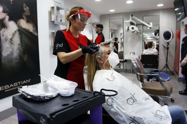 Una peluquera tiñe el pelo a una clienta durante el estado de alarma
