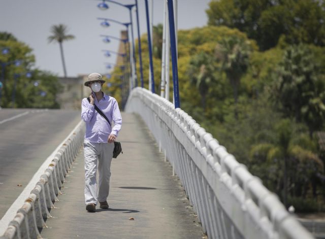 Un hombre con un gorro camina por la pasarela de la Cartuja durante la alerta naranja por altas temperaturas Un hombre con un gorro camina por la pasarela de la Cartuja durante la alerta naranja por altas temperaturas