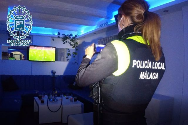 Agente de la Policía Local de Málaga desalojando un bar que incumplía la normativa Agente de la Policía Local de Málaga desalojando un bar que incumplía la normativa