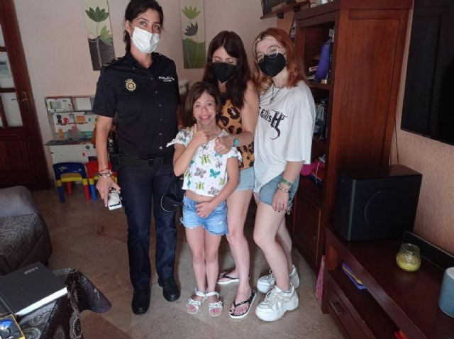 Un agente de la Policía Nacional de Huelva junto a la niña y su familia