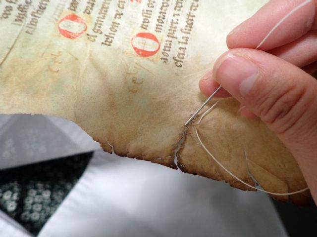 Costura de un desgarro en un documento restaurado